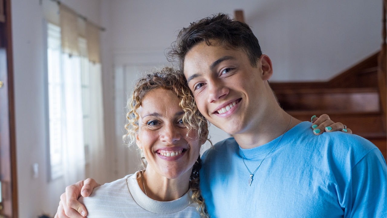 Portrait of grateful teenager man hug smiling middle-aged mother show love and care, thankful happy grown-up son in embrace cheerful mom, enjoy weekend family time at home together, bonding concept